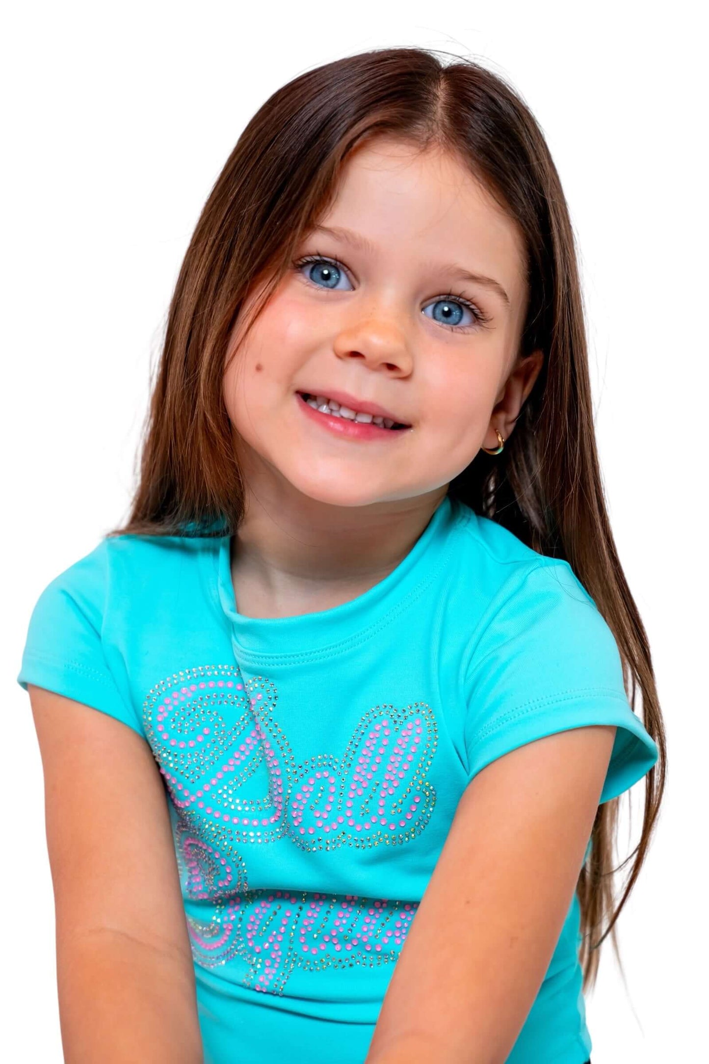 Girl wearing a Doll Squad Baby Tee in turquoise with sparkle detailing, smiling brightly.