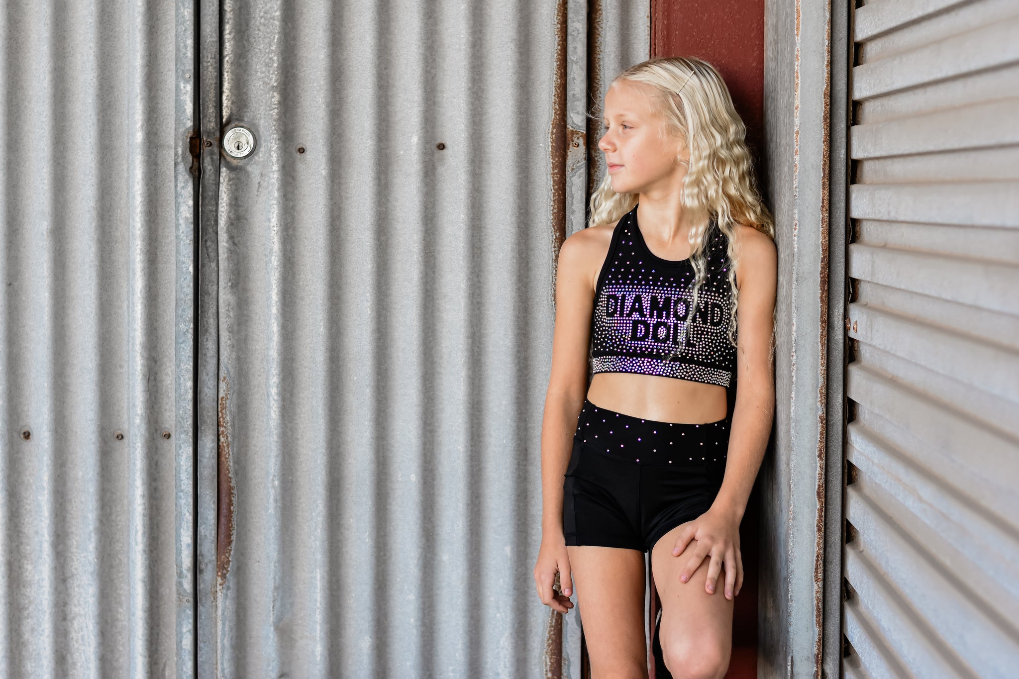 Girl in Diamond Doll Rhinestone - Crop activewear, showcasing rhinestone logo and stylish design.