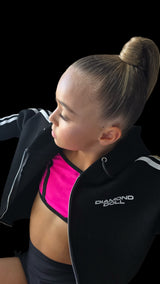 Woman wearing a black jacket with 'Diamond' branding, posing against a black background