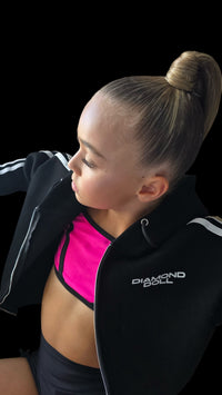 Woman wearing a black jacket with 'Diamond' branding, posing against a black background
