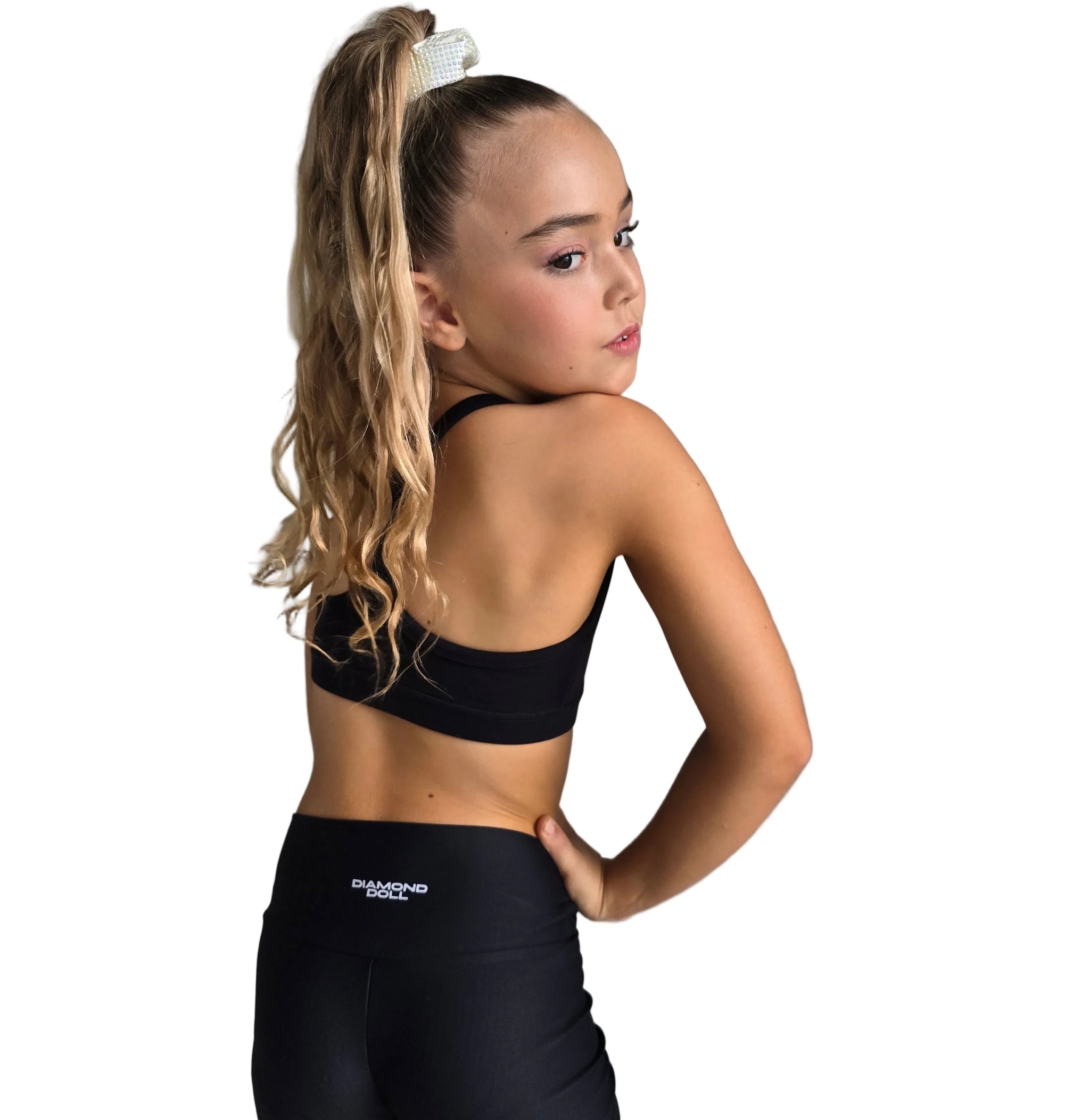 STUDIO ESSENTIALS - SHORTS model showcasing the back view of high-waisted active shorts in a dance-ready outfit.
