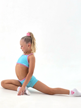 Girl performing a split in Blue Crush - Crop activewear set featuring baby blue and pink trim.