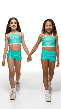 Two girls wearing Teal Sky Bottoms and matching crop tops, showcasing playful fashion and comfort.
