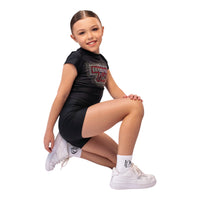 STUDIO ESSENTIALS - SHORTS model wearing high-waisted active shorts in black with white sneakers.