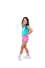 Puff Print Baby Tees model wearing blue tee and pink shorts, showcasing playful style with a confident pose.