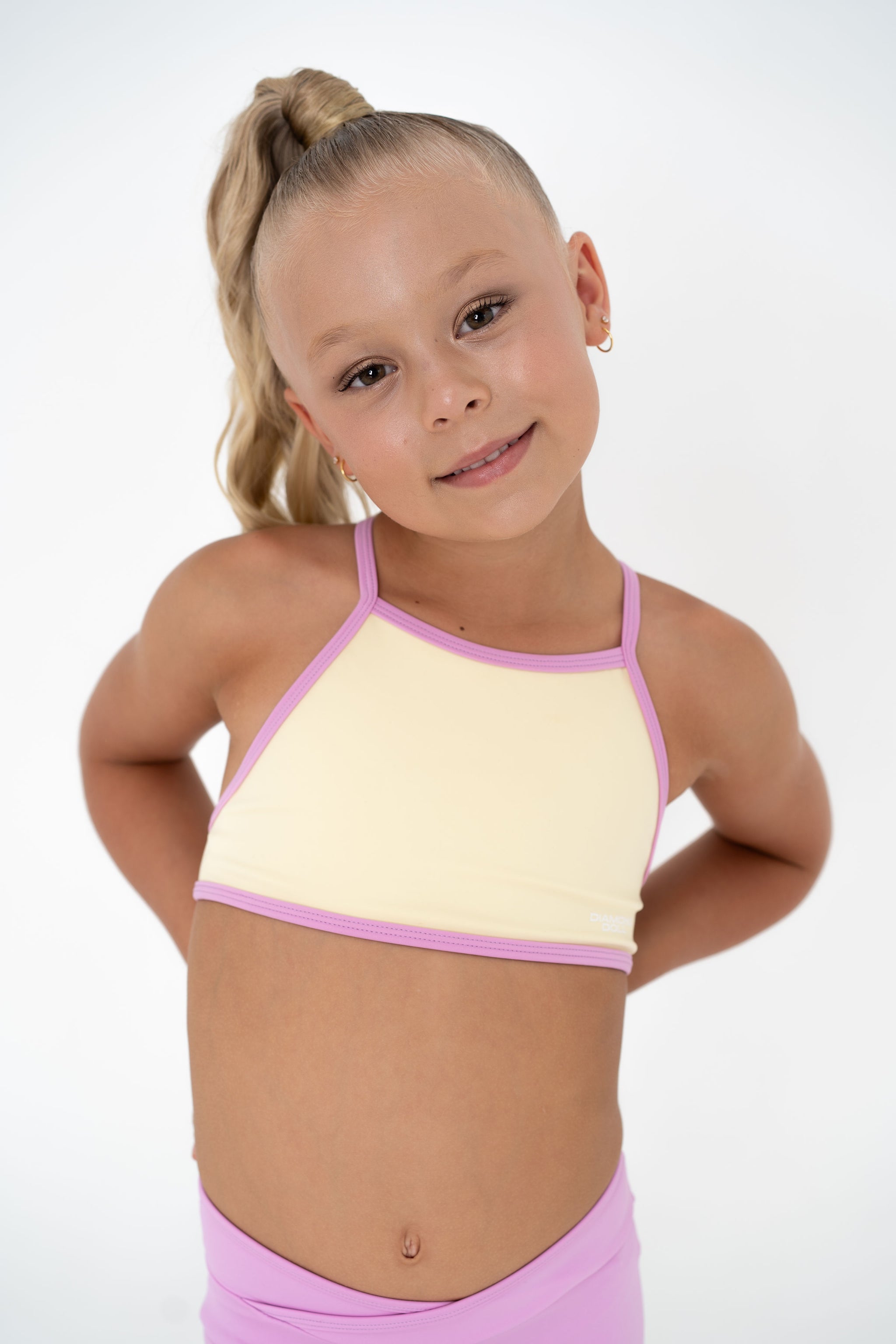 Pink Lemonade – Crop model wearing a pastel yellow and pink activewear top, perfect for summer training.